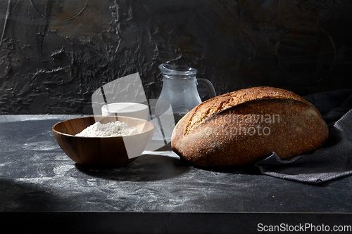 Image of bread, wheat flour, salt and water in glass jug