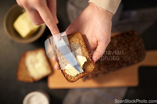 Image of female baker spreading butter on homemade bread