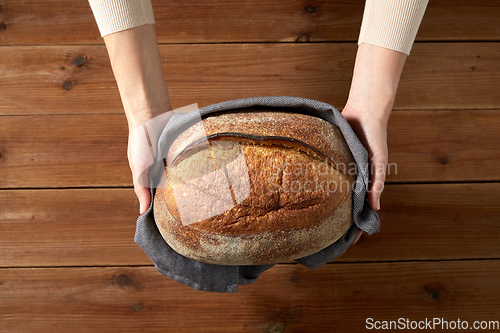 Image of female baker with homemade bread at bakery