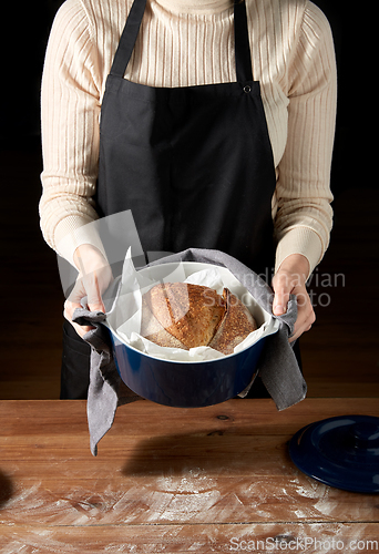Image of female baker with homemade bread at bakery
