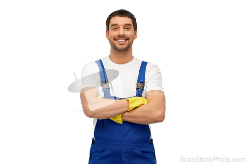 Image of happy male worker or cleaner in overall and gloves