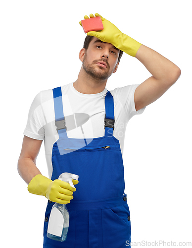 Image of tired male cleaner with sponge and detergent