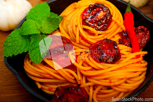 Image of italian spaghetti pasta and tomato with mint leaves