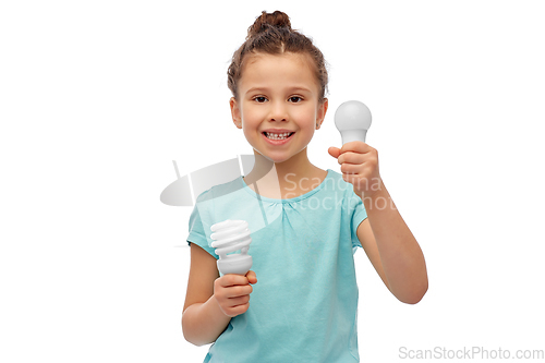 Image of smiling girl comparing different light bulbs