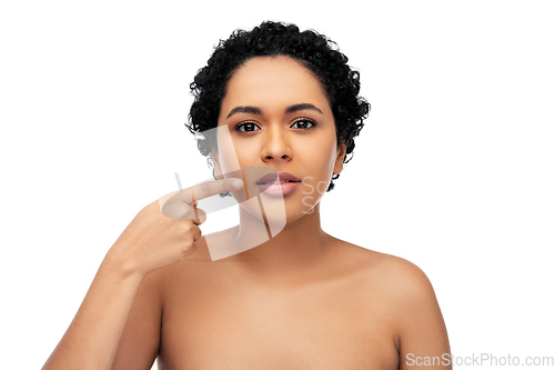 Image of young african american woman pointing to her lips