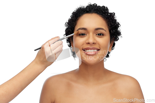 Image of happy woman and hand of make up artist with brush