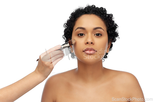 Image of woman and hand of make up artist with brush