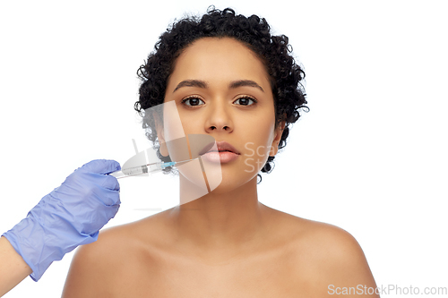 Image of face of african woman and hand with syringe