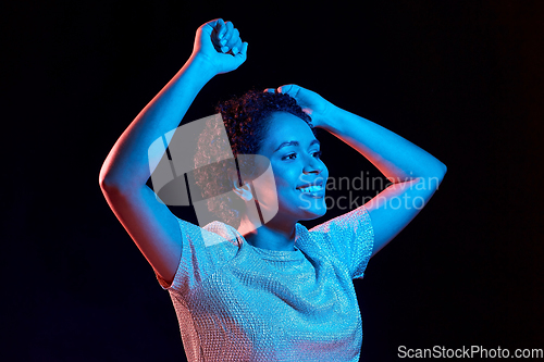 Image of african american woman dancing over neon lights