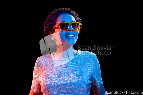 Image of african woman in sunglasses over neon lights
