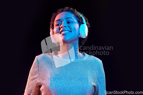 Image of woman in headphones listening to music and dancing