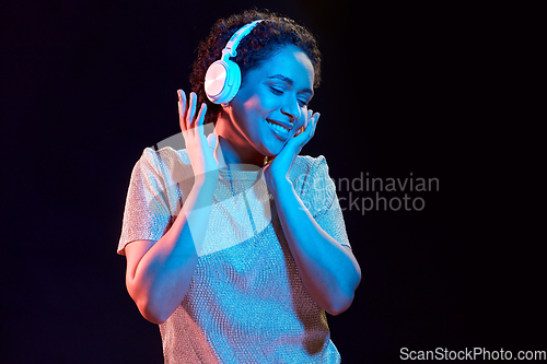 Image of woman in headphones listening to music and dancing