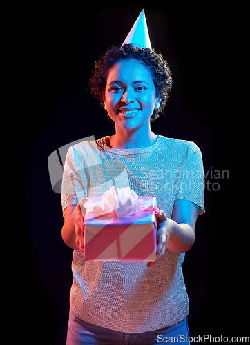 Image of african woman in party cap with gift box on black