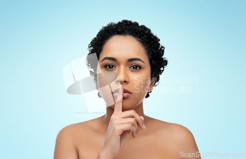 Image of young african american woman with finger on lips