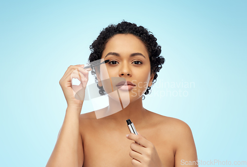 Image of beautiful african american woman applying mascara