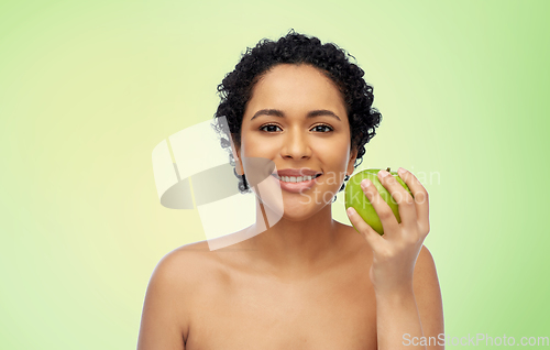 Image of happy african american woman holding green apple