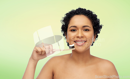 Image of smiling woman with toothbrush cleaning teeth