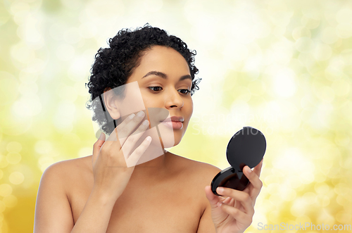 Image of african american woman looking to mirror