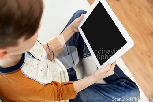 Image of close up of boy with tablet pc computer at home