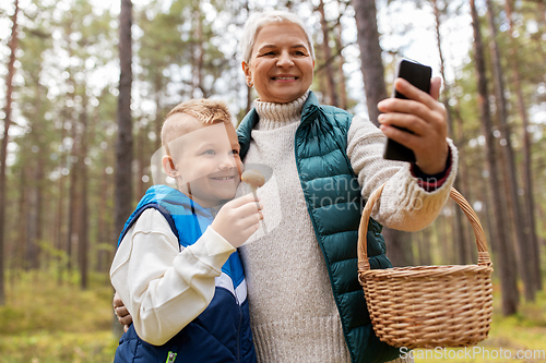 Image of grandmother and grandson with baskets take selfie