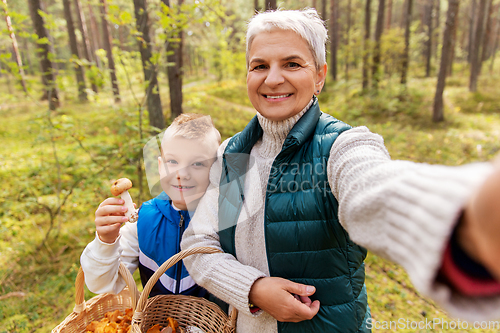 Image of grandmother with grandson taking selfie in forest
