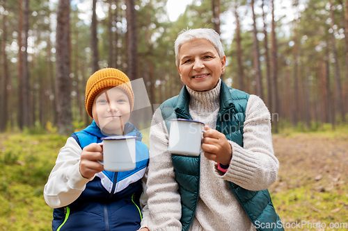 Image of grandmother with grandson drinking tea in forest