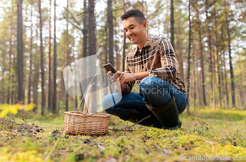 Image of man using smartphone to identify mushroom