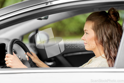 Image of woman or female driver driving car in city