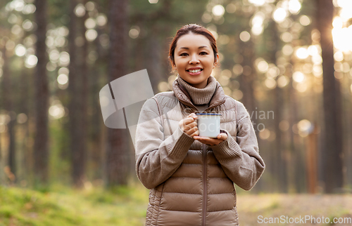 Image of asian woman with mug drinking tea in forest