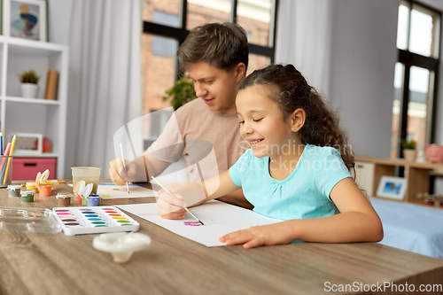 Image of happy father with little daughter drawing at home