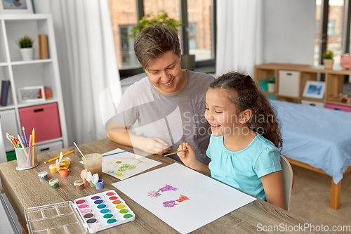 Image of happy father with little daughter drawing at home