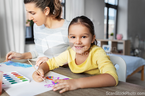 Image of mother with little daughter drawing at home