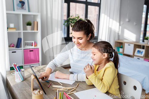Image of mother and daughter with tablet pc drawing at home