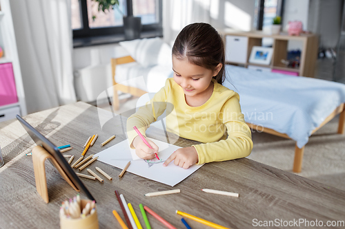 Image of little girl drawing with coloring pencils at home