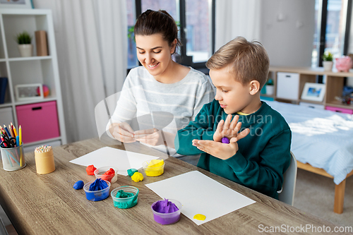 Image of mother and son playing with modeling clay at home