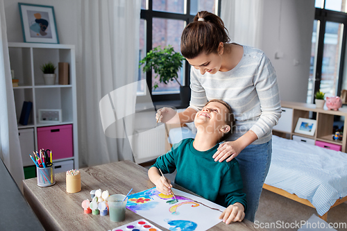 Image of mother and son with colors drawing at home