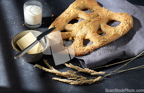 Image of close up of cheese bread, butter, knife and milk
