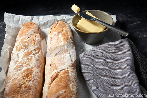 Image of close up of bread, butter and knife on towel
