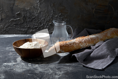 Image of bread, wheat flour, salt and water in glass jug