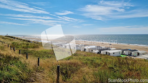 Image of View from dunes on North Sea city beach on a sunny summer weekend. Typical pavilions. Zandvoort, Netherlands