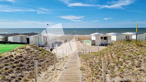 Image of View from dunes on North Sea city beach on a sunny summer weekend. Typical pavilions. Path to North sea beach. Zandvoort, Netherlands