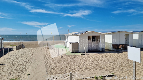 Image of View from dunes on North Sea city beach on a sunny summer weekend. Typical pavilions. Path to North sea beach. Zandvoort, Netherlands