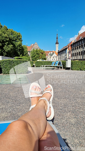 Image of Slender tanned female legs in white shoes, selfie