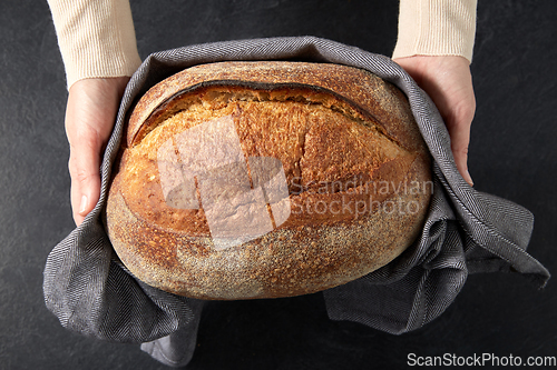 Image of female baker with homemade bread at bakery