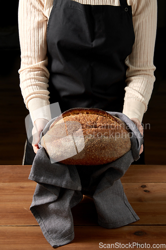 Image of female baker with homemade bread at bakery