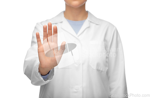 Image of female doctor in white coat showing stop gesture