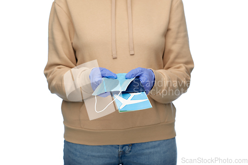 Image of woman with mask, passport and air ticket