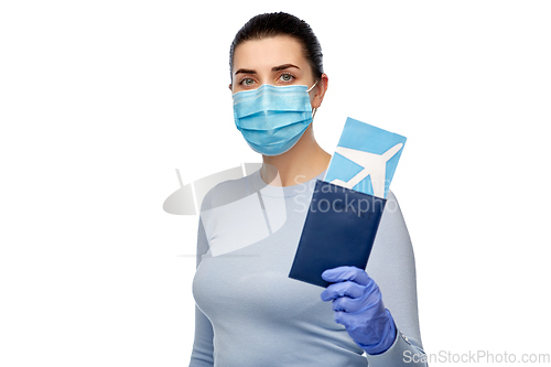 Image of young woman in mask with air ticket and passport