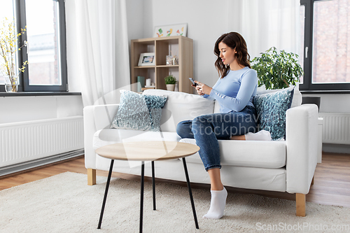 Image of woman with smartphone at home