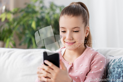 Image of happy smiling little girl with smartphone at home